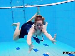 Redhead babe swimming naked in the pool